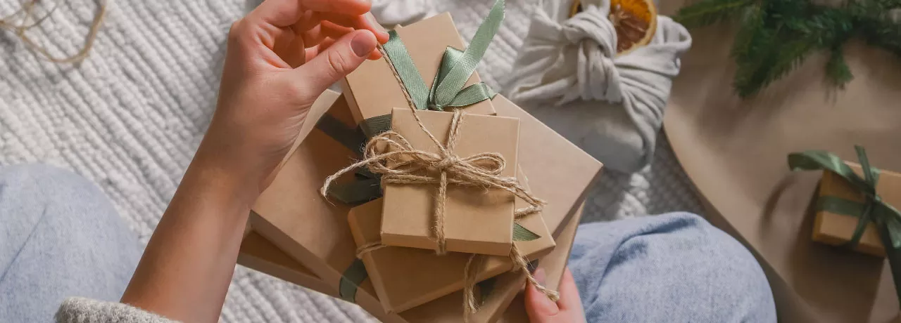 A HR professional manually wrapping a reward for their employee recognition program.