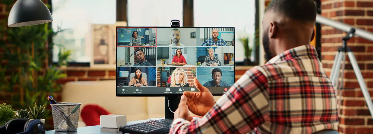 A remote new hire on their computer talking to their team virtually during onboarding
