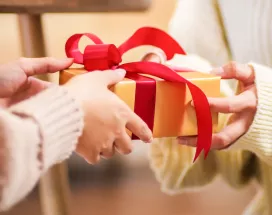 A person handing a gift to another person