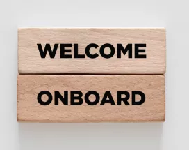Image shows two wooden blocks stacked on top of each other that say "Welcome Onboard"