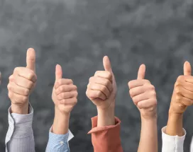 Image shows a bunch of people giving a thumbs up