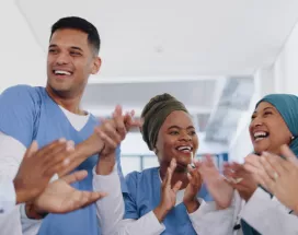 Three nurses and doctors celebrating by clapping their hands