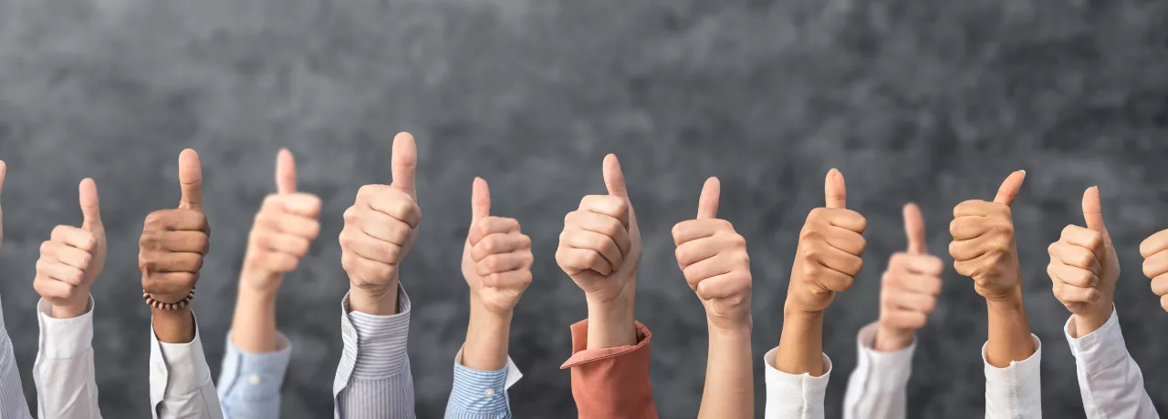 Image shows a bunch of people giving a thumbs up 