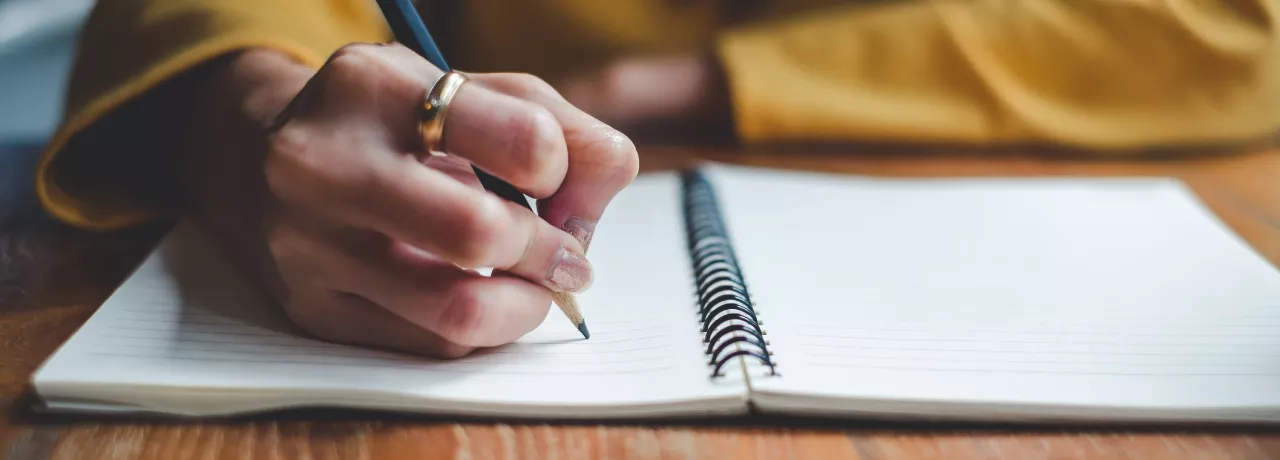 Image shows a close up of a person writing a message 