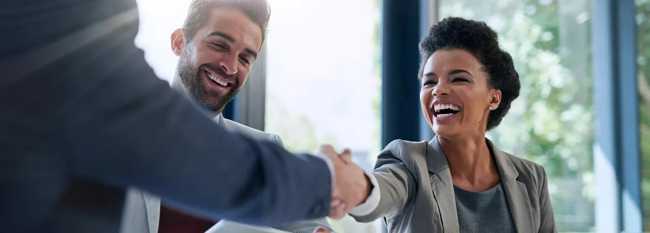 Image shows two employees shaking hands 