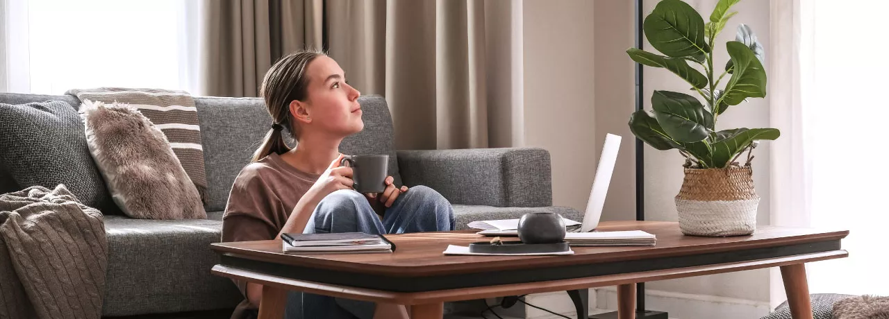 An employee exhibiting work-life balance by working remotely in her living room  