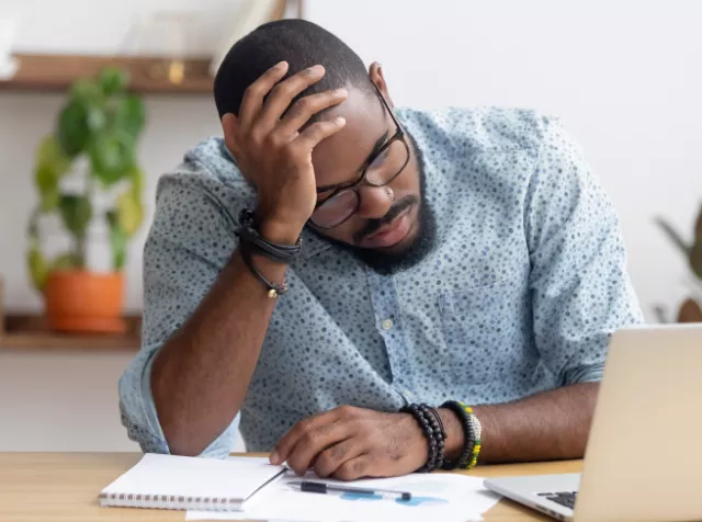 Employee looking down at their computer, looking sad