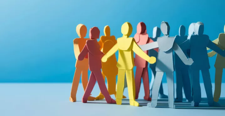 Paper stick figures huddled in a group