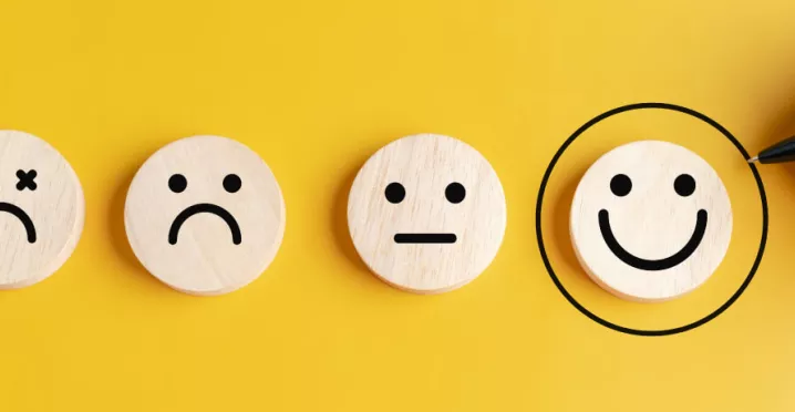 Four circles that display sad to happy faces with the happies smiley face circled