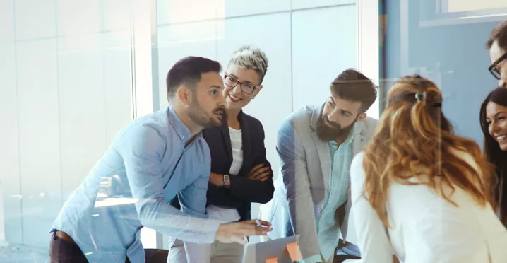 An image showing a team of six people gathered around a table