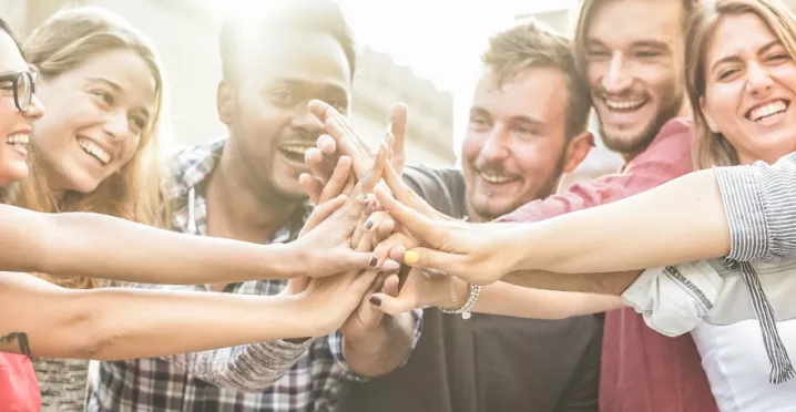An image showing a team putting their hands together