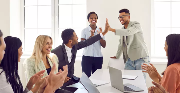 Two employees high fiving over a table