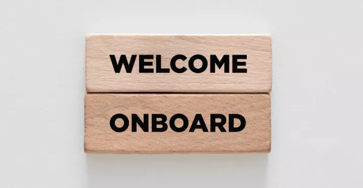 Image shows two wooden blocks stacked on top of each other that say "Welcome Onboard"