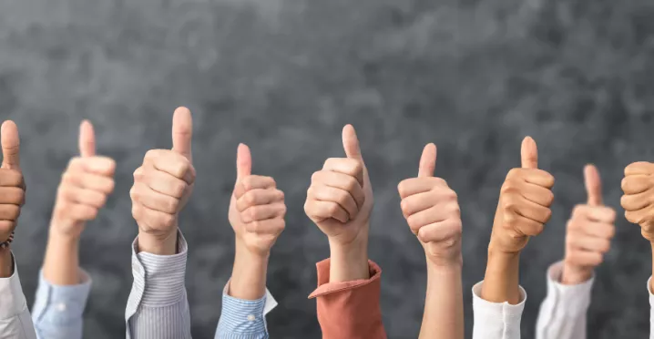 Image shows a bunch of people giving a thumbs up