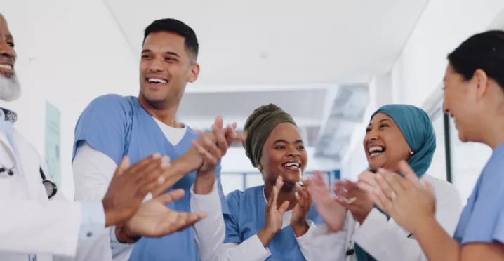 Three nurses and doctors celebrating by clapping their hands