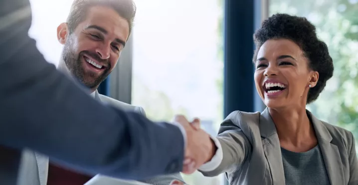 Image shows two employees shaking hands