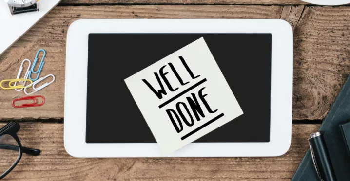 Image shows a sticky note on a desk that says "Well Done"