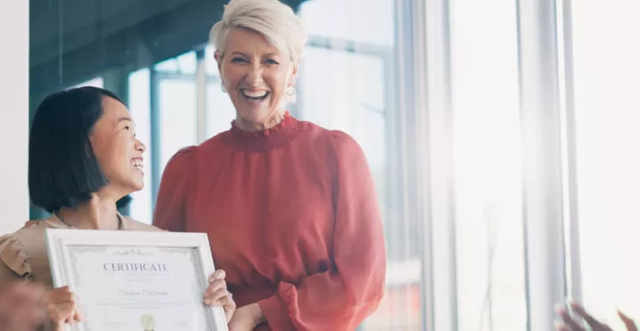 Image shows a leader presenting an employee award to a team member.