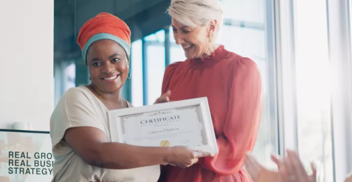 Shows a leader presenting an award to an employee