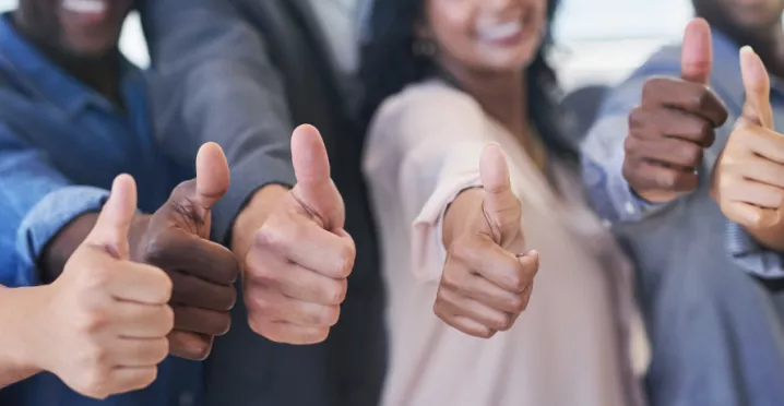 Shows six people giving a thumbs up