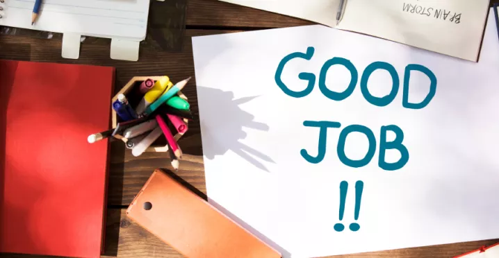 Shows a note that says "Good Job!" on a desk