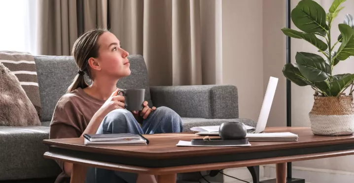 An employee exhibiting work-life balance by working remotely in her living room 
