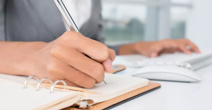 An administrator writing down a task