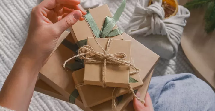 A HR professional manually wrapping a reward for their employee recognition program.