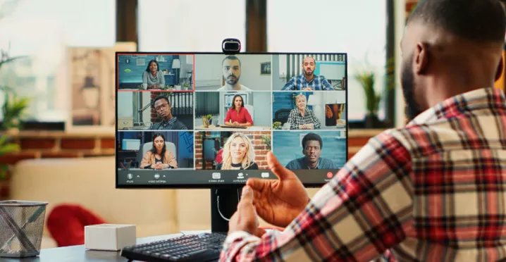 A remote new hire on their computer talking to their team virtually during onboarding