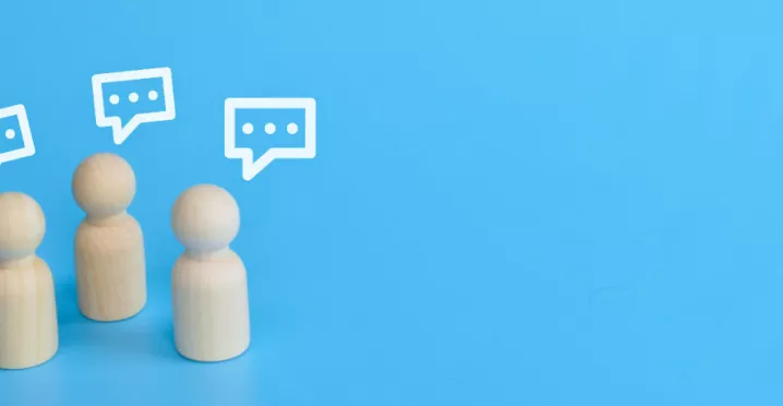 Three wood figurines giving feedback with text boxes over their head