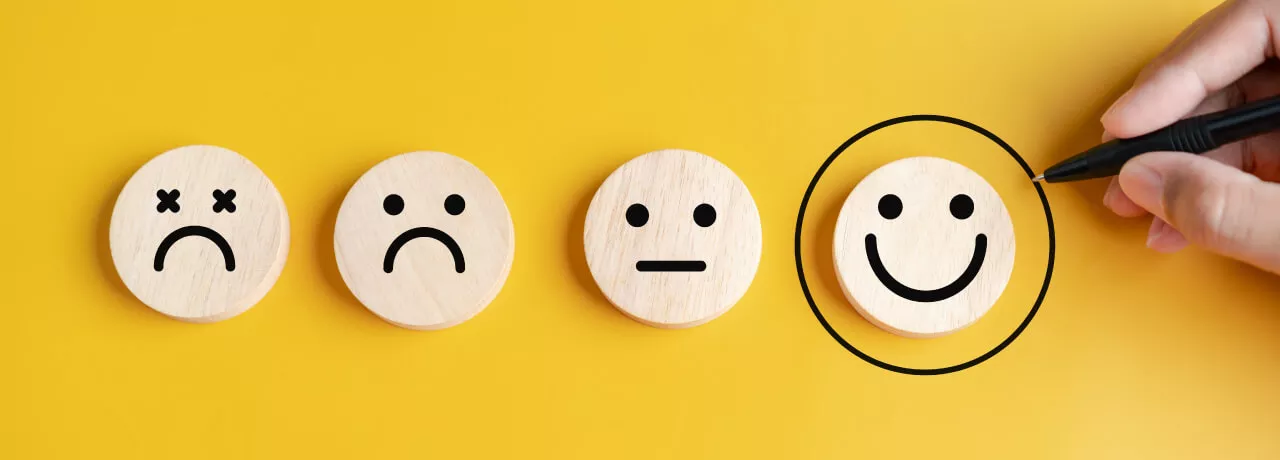 Four circles that display sad to happy faces with the happies smiley face circled