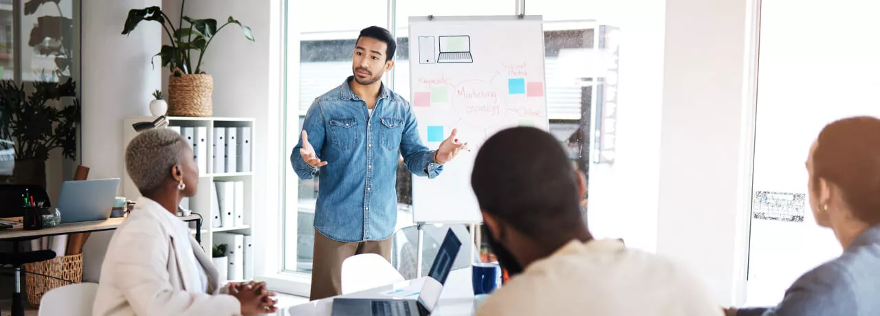 An employee presenting in front of three coworkers