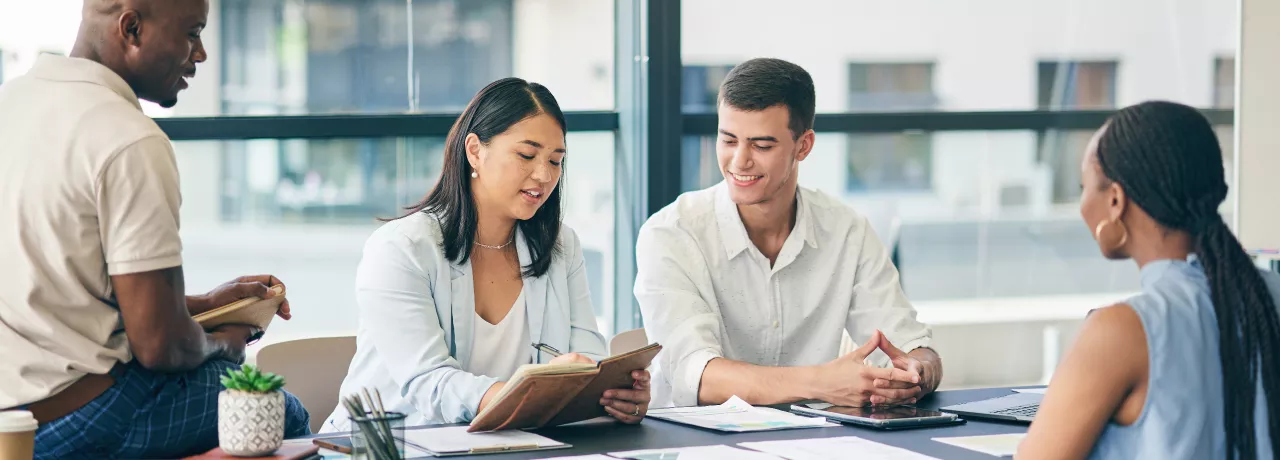Coworkers gathered around a table working on a project