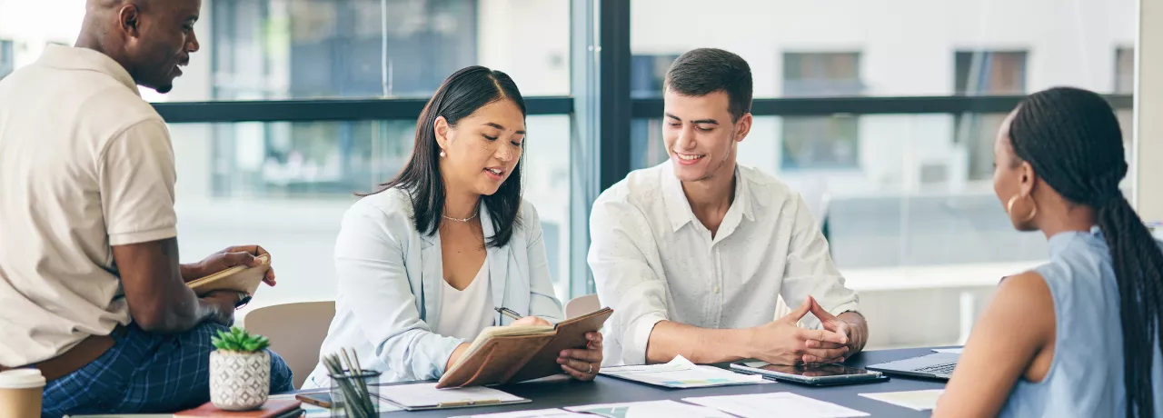 Four employee sitting around a table discussing a project