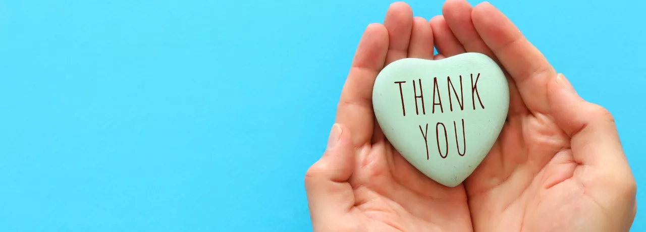 Image shows two hands cupped together with a heart in the middle that says "Thank You"
