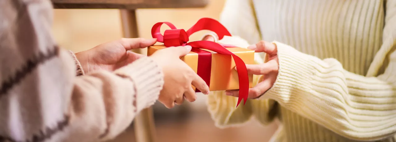 A person handing a gift to another person