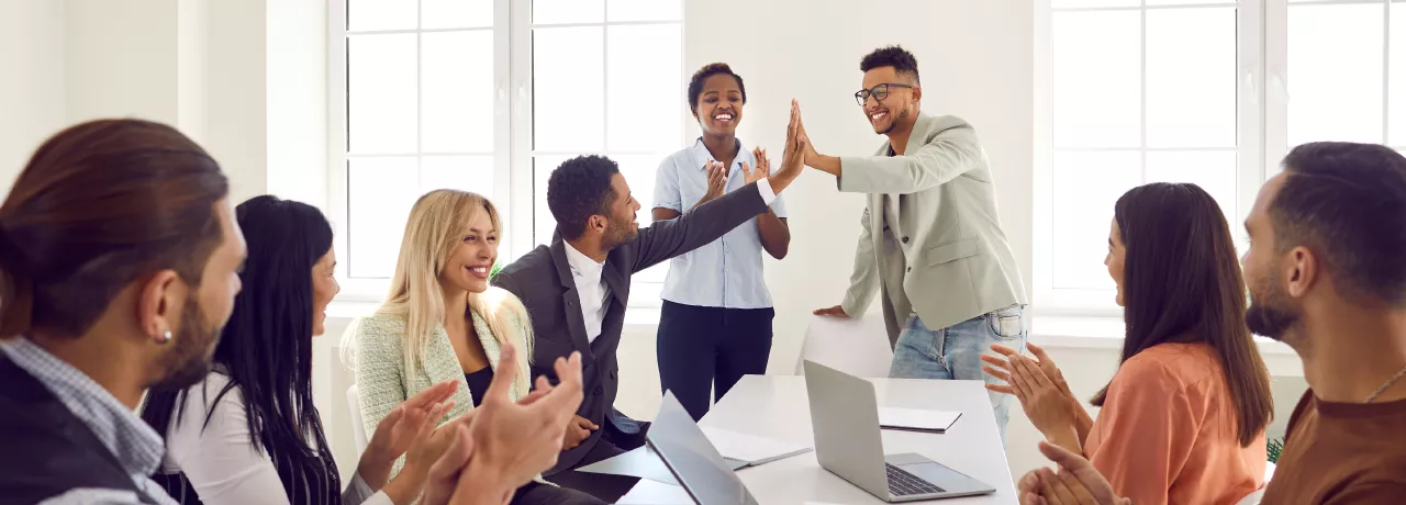 Two employees high fiving over a table