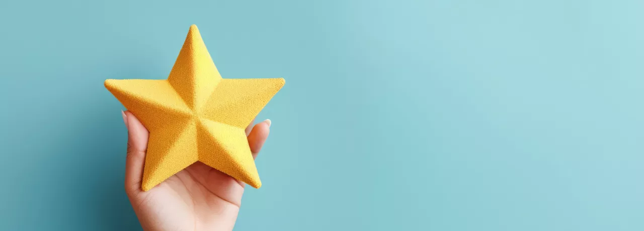 Image shows a hand holding a foam, yellow star.