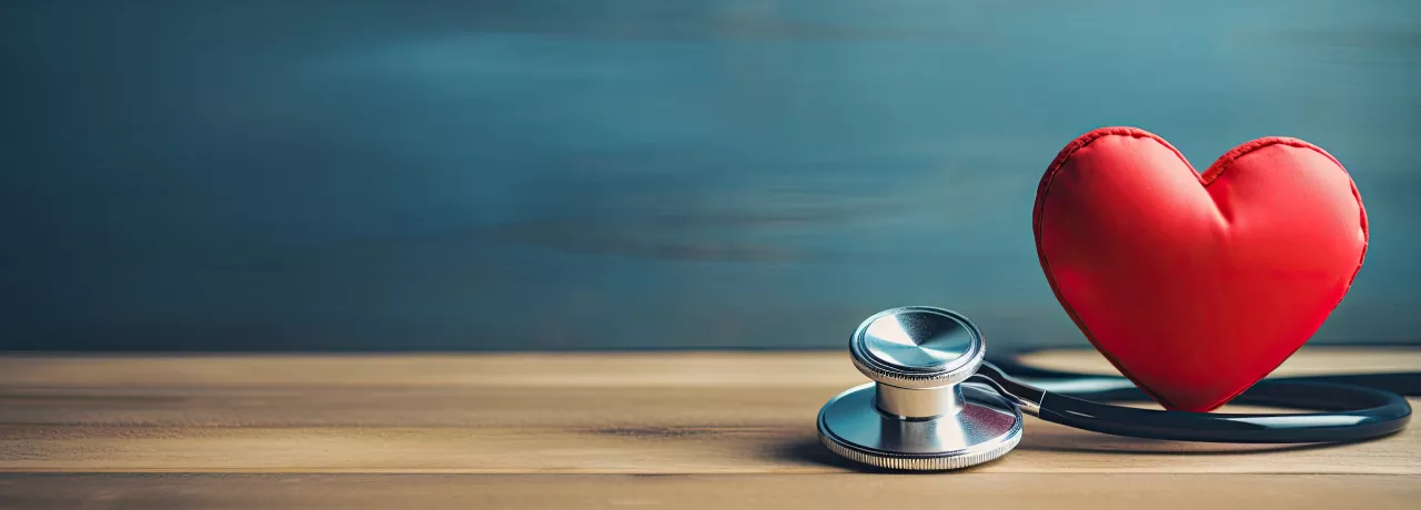 Image shows a toy heart and stethoscope sitting on a table 