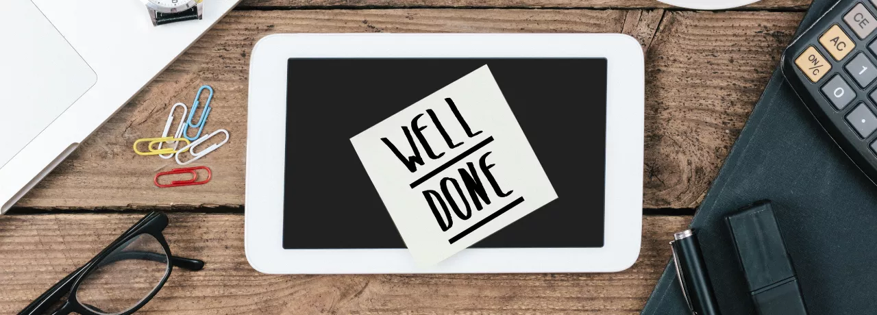 Image shows a sticky note on a desk that says "Well Done"