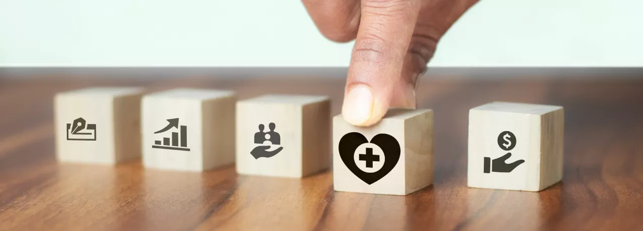 Image shows a hand grabbing a block with a heart on it.