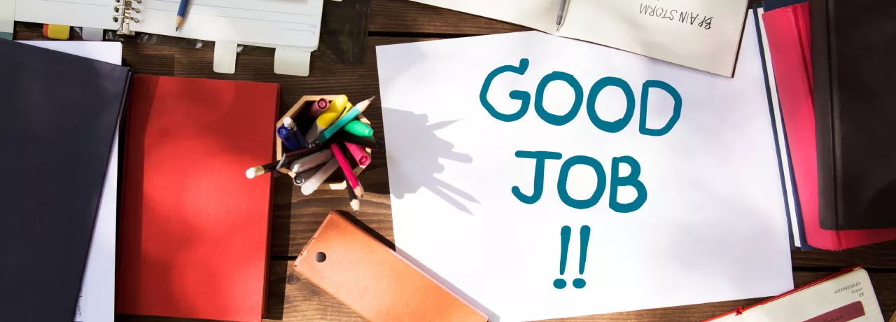 Shows a note that says "Good Job!" on a desk