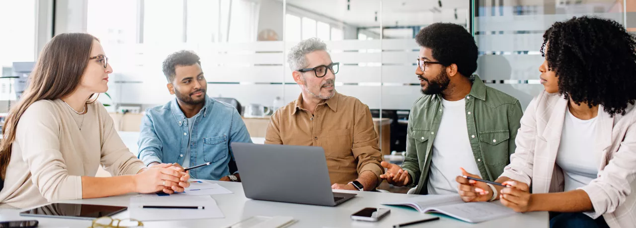 Team of engaged employees collaborating in a modern office, showing how culture helps retain talent