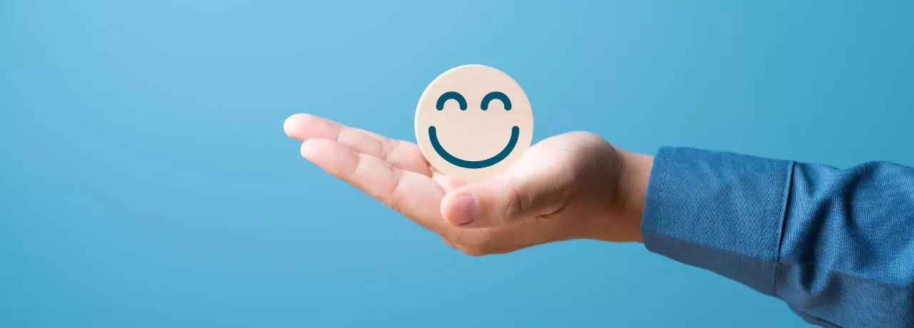 A hand holding a smiling face