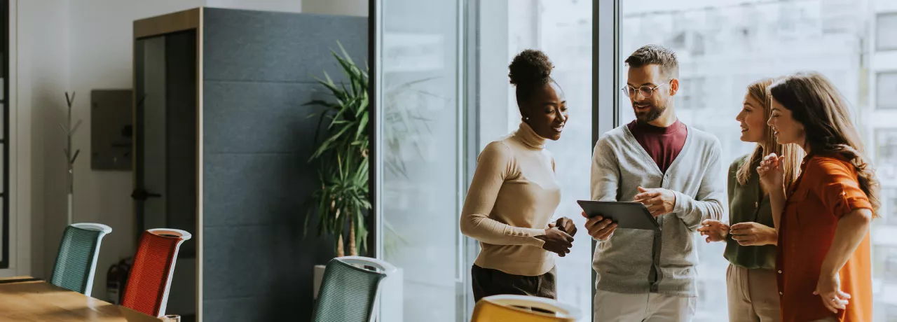 A group of employees working collaboratively together on an tablet.