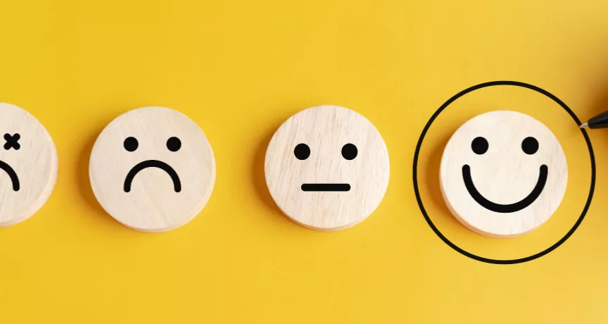 Four circles that display sad to happy faces with the happies smiley face circled