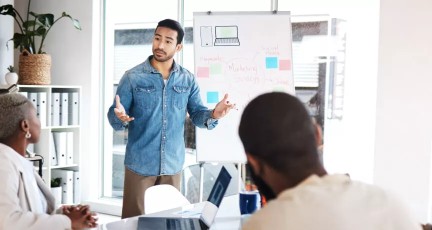 An employee presenting in front of three coworkers