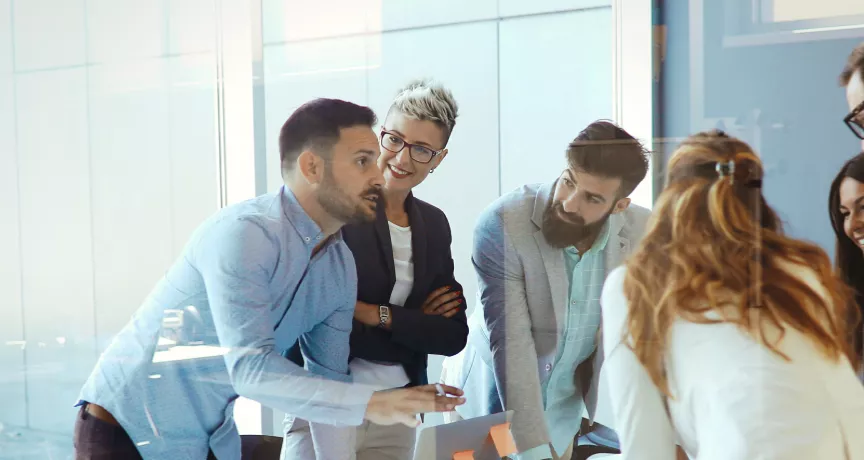An image showing a team of six people gathered around a table