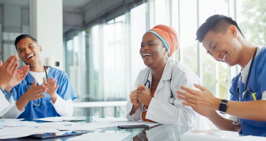 A small group of healthcare workers laughing and smiling at a table