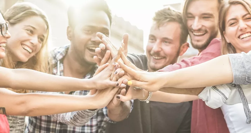 An image showing a team putting their hands together